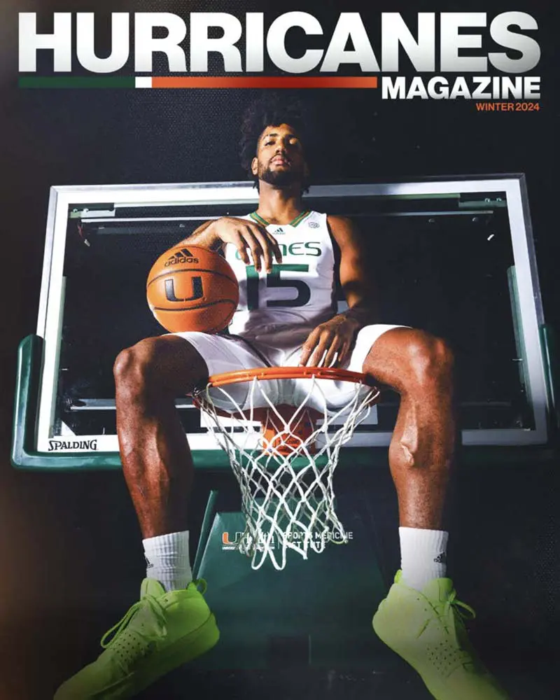 basketball player sitting on hoop with ball